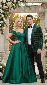 Man in a green plaid suit and woman in a green evening gown standing together outdoors with floral decorations.